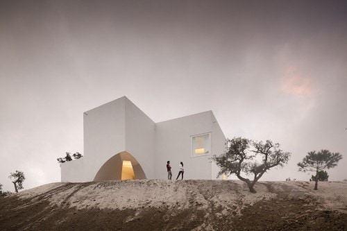 Casa en Fontinha is a minimalist house located in Melides, Portugal, designed by Manuel Aires Mateus. The design is centered around an open courtyard, which overlooks the beautiful landscape beyond. The minimalist white exterior facade is matched with an equally white and simple interior. (1)