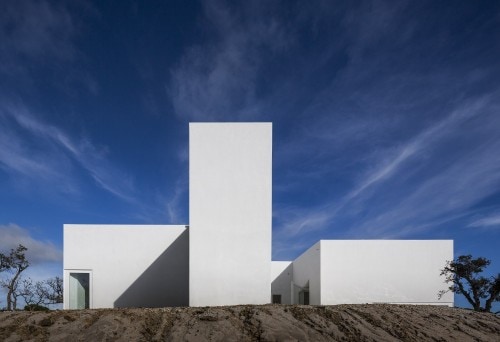 Casa en Fontinha is a minimalist house located in Melides, Portugal, designed by Manuel Aires Mateus. The design is centered around an open courtyard, which overlooks the beautiful landscape beyond. The minimalist white exterior facade is matched with an equally white and simple interior. (3)