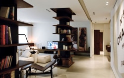 Giolitti is a minimalist house located in Turin, Italy, designed by Fabio Fantolino. The living room features two wooden bookshelf columns that span from the floor to the ceiling. The mixed concrete floors are accented with light grey and wooden furniture. The kitchen and bathrooms utilize natural-toned materials juxtaposed against wooden cabinetry. (2)
