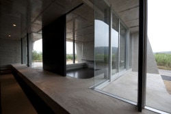 Banna House is a minimalist design created by Japan-based designer Noriyoshi Morimura Architect & Associates. The concrete structure is characterized by its unique angular architecture. Appearing almost as a pavilion of sorts, panoramic windows span the length of the building to provide views of the mountain landscape. The interior is also constructed of the exposed concrete, and is juxtaposed against black walls. (10)