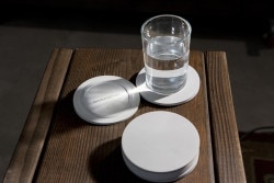 Tilt Coaster is a minimalist design created by York-based designer Snarkitecture. Appearing at first as a familiar round coaster, the angled top surface of Tilt Coaster is revealed when a drink is placed on it. (1)