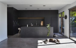 M House is a minimalist house located in Melbourne, Australia, designed by DKO. The kitchen space features blacked out custom cabinetry with a black kitchen island that allows for seating and serving. (2)