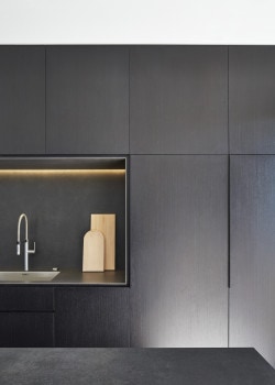 M House is a minimalist house located in Melbourne, Australia, designed by DKO. The kitchen space features blacked out custom cabinetry with a black kitchen island that allows for seating and serving. (3)