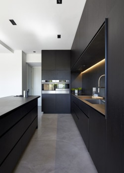 M House is a minimalist house located in Melbourne, Australia, designed by DKO. The kitchen space features blacked out custom cabinetry with a black kitchen island that allows for seating and serving. (5)